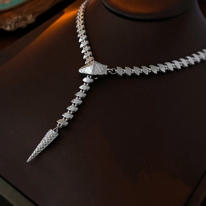 Macro shot of silver snake-shaped Y-necklace showing scale texture and tapered tail