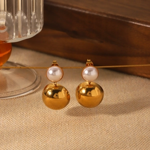 Detail view of 18k gold plated hoop earrings with round white pearl studs