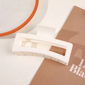 Detail of a large matte white rectangular hair claw clip for thick hair styling