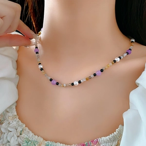 Detailed view of handmade multi-color beaded necklace featuring purple and grey pearls