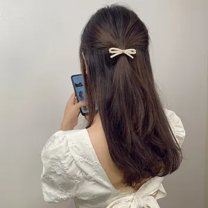 Detailed view of rhinestone bow hair clip styled on a half-up hairstyle for women
