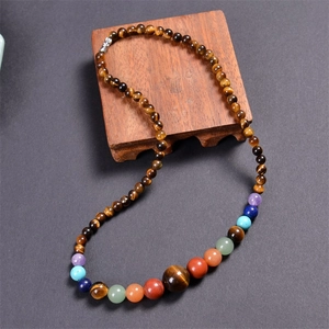 Detailed view of bohemian tiger eye beaded necklace with colorful chakra natural energy stones