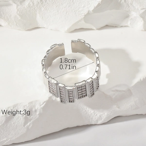 Irregular silver-plated copper ring with cubic zirconia inlay on white stone surface