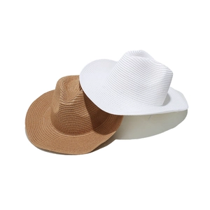 Close-up of woven paper straw texture on white and tan panama fedora sun hats