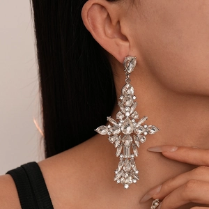 Close-up of vintage palace style cross earrings with sparkling rhinestones on model