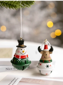 Macro shot of snowman and reindeer metal Christmas bell ornaments with hanging strings