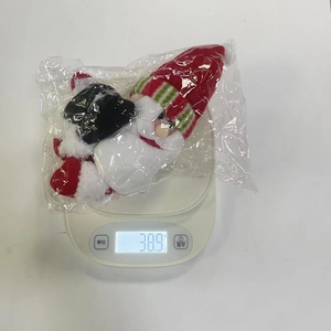 Close-up of a plush Santa wine bottle cover weighing 38.9g on a digital scale