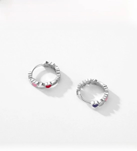 Close-up of S925 silver hoop earrings featuring colorful heart-shaped enamel patterns
