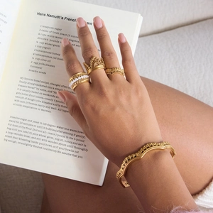 Elegant 18K gold lace open bangle and pearl ring set on model holding a book