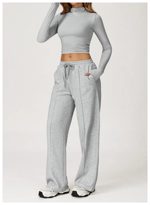 Full body view of grey quick-dry athletic set with long sleeve crop top and wide leg pants