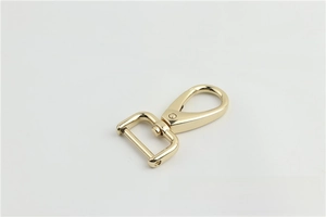 Close-up of golden swivel lobster clasp with D-ring for handbag strap hardware