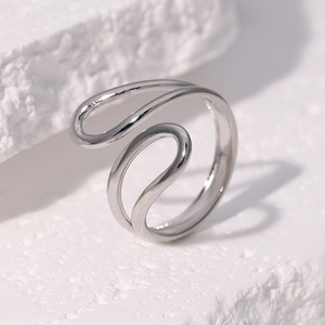 Minimalist silver wavy stainless steel open ring shown on a white textured stone background