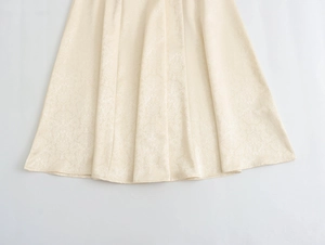 Détail macro du tissu jacquard beige crème et de la texture sur l'ourlet de robe