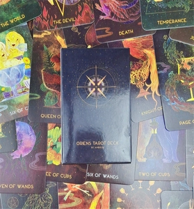 Overhead shot of Oriens Tarot Deck with scattered cards and blue illustrated box