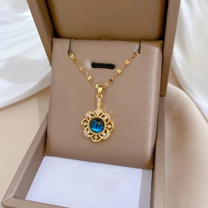 Luxurious gold flower necklace with blue crystal pendant set in elegant jewelry box
