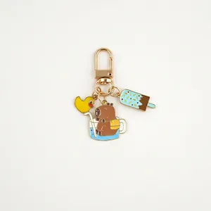 Detailed close-up of Kapybara enamel pendants with duck and ice cream keychain charms