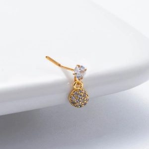 Macro shot of gold stainless steel nose stud with zircon pendant on white background