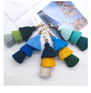 Detail view of 6 colorful three-tier tassel keychains with golden lobster clasps