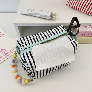 Detail of striped fabric tissue pouch with colorful wooden bead chain handle