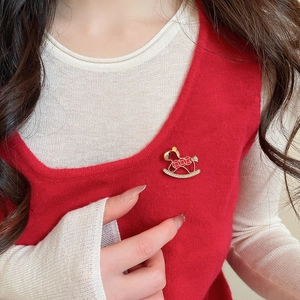 Detail of red enamel rocking horse brooch with gold accents and sparkling rhinestones