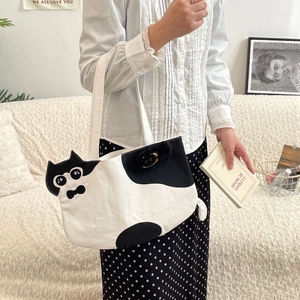 Detail of cartoon cat tote bag with cute ears, plush pendant, and large capacity