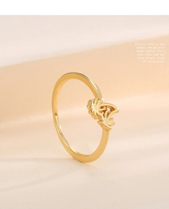Close-up of a minimalist gold palm tree ring showing delicate tropical design details