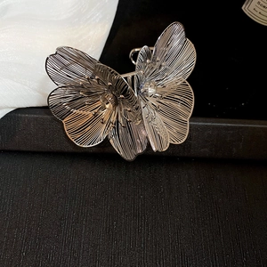 Close-up of a silver hollow-out butterfly hair claw clip with detailed metal craftsmanship