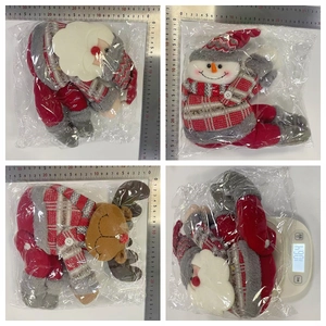 Detailed view of Christmas plush dolls with ruler and scale showing 106.1g weight