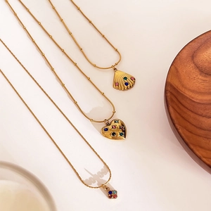 Golden stainless steel necklace with shell and heart charms featuring colorful rhinestones
