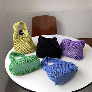 Detailed view of woven cotton rope tote bags in yellow, black, purple, green, and blue colors