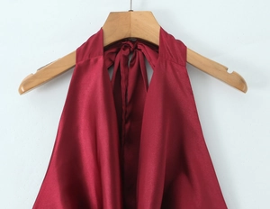 Détail d'un haut licou en satin bordeaux avec décolleté drapé et texture soie brillante