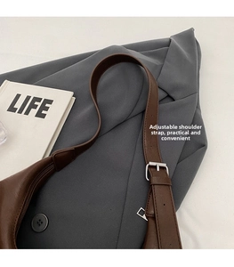 Detail of adjustable silver buckle and stitching on a premium brown leather tote bag