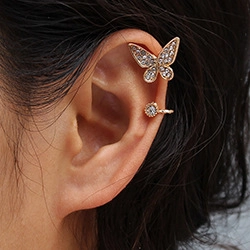 Close-up of a gold-plated butterfly ear cuff and stud earring set with sparkling rhinestones