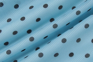 Détail de tissu en résille bleu clair à pois noirs avec texture plissée douce