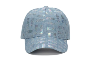Detail of light blue denim baseball cap featuring iridescent QUEEN lettering and laser finish