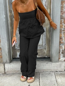 Détail d'un haut bustier noir et d'un pantalon large assorti porté par un mannequin