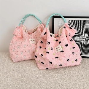 Detail of pink bubble fabric tote bags with bunny and cat patterns and plaid handles
