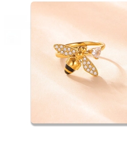 Macro detail of a bee ring with gold finish, enamel body, and heart-shaped cubic zirconia