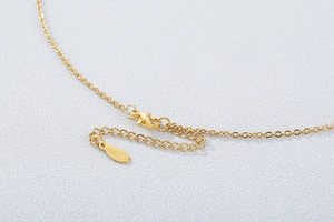 Macro view of gold-plated necklace clasp with S925 engraved authenticity tag