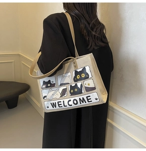 Detail of canvas tote bag featuring cute cat illustrations and Welcome text design