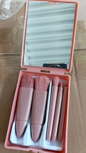 Pink travel makeup brush set in a plastic mirror case featuring five functional brushes