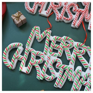 Detail of Merry Christmas letter sign ornament with red and green candy cane stripes
