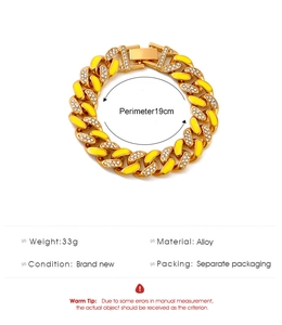 Dettaglio del bracciale a catena cubana dorata con smalto giallo e strass bianchi