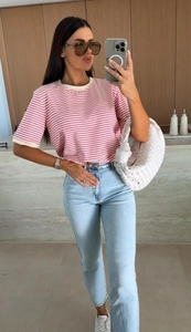 Gros plan d'un t-shirt à rayures rouges et blanches assorti à un jean denim bleu clair