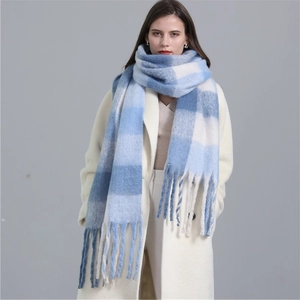 Detail of blue and white plaid scarf featuring thick cashmere-like fabric and long tassels