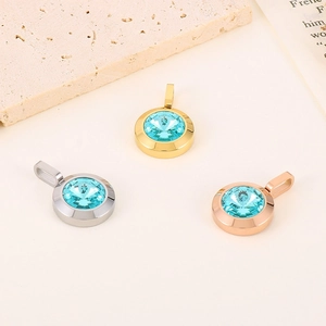 Macro view of round light blue crystal pendants in gold, silver, and rose gold finishes