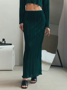 Detailed texture of dark green pleated fabric set with long sleeves and maxi skirt