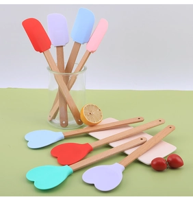 Set of colorful heart-shaped and flat silicone spatulas with natural beech wood handles