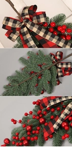 Detail of Christmas PE red berry swag featuring pine needles and plaid bow ornaments