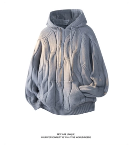 Detail of cable knit texture on a light blue-grey hooded sweater with kangaroo pocket
